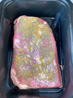 a piece of meat in a roasting pan with gold flecks