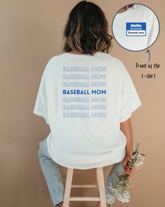 "Elevate your baseball mom style with our \"I'm a Proud Baseball Mom\" T-shirt. This long-sleeved t-shirt features a two-sided design with a repeating \"baseball mom\" phrase on the back and a \"Hello, I'm a proud baseball mom\" tag on the front left side. This t-shirt is perfect for baseball, home and away games, or everyday casual wear.  Show your love and pride for the baseball player in your family, or make this the perfect gift for a baseball mom. This shirt is made from 100% cotton. This white shirt is available in three colors: red, blue and green. If you would like this shirt in a specific color that we are not currently offering, get in touch, and we're happy to print a custom color." Sporty Crew Neck T-shirt For Mother's Day, Sporty Graphic Print T-shirt For Mother's Day, White Letter Print Top For Baseball Season, College Baseball Season Screen Print Tops, Cotton Baseball Jersey With Letter Print For Fans, Baseball Season Graphic Tee With Name Print, Graphic Tee With Name Print For Baseball Season, Relaxed Fit T-shirt For Baseball Season, Letter Print Baseball Season Fan Tops