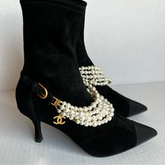 Authentic Used Excellent Used Condition No Box/ Dust Bags 35c Chanel 21a Collection These Stretch Black Suede Ankle Boots Feature Multiple Strings Of Faux Pearl Embellishment At Vamp With Goldtone Cc Charm Buckled With The Goldttone Buckles. The Buckles Are Adjustable As Well So You Can Loosen Or Tighten The Entire Embellishment Piece Or Remove It Completely (The Buckles Are Not Removable). Pointed Grosgrain Cap Toe. Back Zip. 2.75 Kitten Heel. 6.5" Shaft. Padded Leather Insole And Leather Sole. Made In Italy. The Booties Are Made From Stretch Suede Calfskin Leather. Channel Boots, Luxury Ankle Boots With Heel Pull Tab, Luxury Ankle Boot Heels With Buckle Closure, Chanel Black Ankle Boots, Luxury Ankle Boots With 4-inch Heel, Black Ankle Boots With Faux Fur Trim, Black Suede Ankle Boots, Chanel Shoes, Suede Ankle Boots