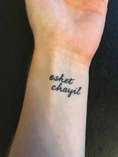 a person with a wrist tattoo that says, eshet chayi