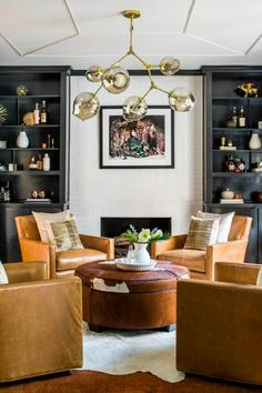 a living room filled with lots of furniture and bookshelves on top of shelves