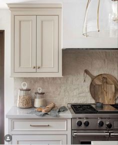 a kitchen with an oven, stove and counter top in the middle of it's white cabinetry