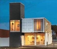 a building made out of shipping containers sitting on the side of a road at night