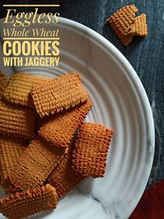 eggless whole wheat cookies with jagery on a white plate next to some crackers