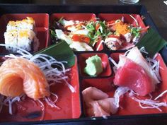 an assortment of sushi on a red tray