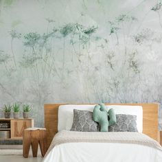 a bedroom with a bed, nightstands and plant wallpaper on the walls behind it