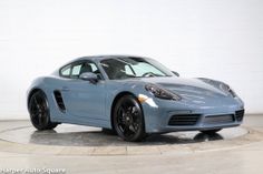 a blue sports car is parked on a circular surface in front of a white wall