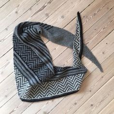 a black and white scarf laying on top of a wooden floor