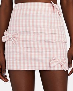 BERNADETTE's pieces are designed to evoke joy and optimism. Tailored from a delightful gingham taffeta this Taffi mini skirt has a curve-hugging silhouette that's appliquéd with tonal bows. Wear yours with a top and heels in different shades of pink.   Fabric: 100% polyester.   Concealed side zip closure.   Dry clean.   Imported.       Length from waist to hem: 14".   Model is wearing size FR 36.  Model height 5'10", bust 30", waist 23", hips 33".      Item is listed in French sizing, please mak Printed Mini Skirt, Skirt With Bow, Hugging Silhouette, Different Shades Of Pink, Woman's Fashion, Pink Gingham, Gingham Print, Shades Of Pink, Pink Fabric