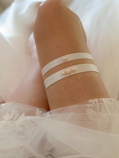 Introducing our Bespoke and Minimalistic Ivory Pearl Bridal Garter.   This Pearl adorned garter is all about comfort and style. Crafted from stretchy elastic, It is customized and designed to fit perfectly, ensuring you're at ease as you dance the night away. All Olivelli Bridal garters are delicately hand-stitched. Crafted with love and attention to detail, this garter is more than an accessory - it's a cherished keepsake! MAKE MEMORIES LAST - Compliment your main garter with a beautiful toss garter, and cherish one as a keepsake. Whether you prefer just the keepsake garter or both the keepsake and toss garter as a set, simply add your selection to your cart upon checkout! UNIQUELY BESPOKE - Our garters are delicately hand-stitched creating an exclusive design with unmatched quality. - Pe Bridal Garters, Wedding Garters, Bridal Garter, Wedding Garter, Pearl Bridal, Make Memories, Ivory Pearl, Bridal Pearls, Bridal Wedding