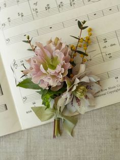 a bouquet of flowers sitting on top of sheet music