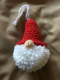 a red and white crocheted santa claus ornament