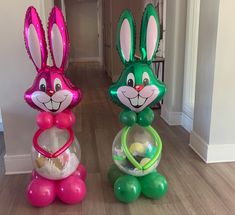 two inflatable easter bunnies sitting on top of a wooden floor next to each other