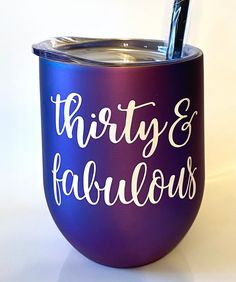 there is a purple cup with the words thirty and fabulous on it