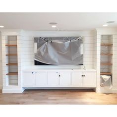 a room that has been decorated with white paint and shelving units in the background