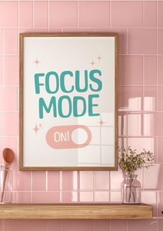 a pink tiled wall with a wooden shelf below it and a poster that says focus mode on