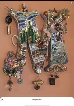 a wall mounted art piece on the side of a building with lots of beads and charms hanging from it's sides