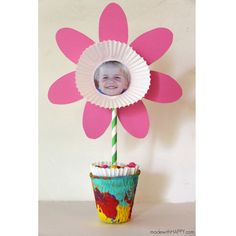 a cupcake with a paper flower on top and a straw sticking out of it