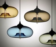 three different colored glass pendant lights hanging from the ceiling in an assortment of shapes and sizes