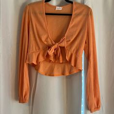 Size M. Orange Top. Long Sleeve. Never Worn. Cute Long Sleeve Orange Top, Cute Long Sleeve Tops For Spring, Cute Long Sleeve Spring Tops, Trendy Cropped Top For Brunch, Cute V-neck Top For Fall, Chic Cropped Orange Top, Chic Orange Top For Brunch, Trendy Orange Top For Day Out, Orange Crop Top For Day Out