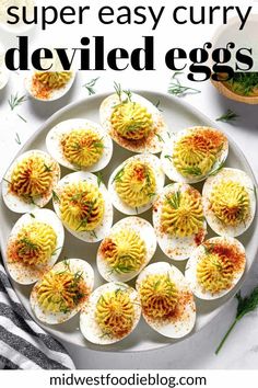 deviled eggs on a white plate with herbs