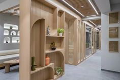 an empty room with shelves and potted plants