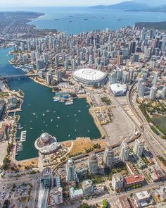 an aerial view of a city with lots of tall buildings and boats in the water