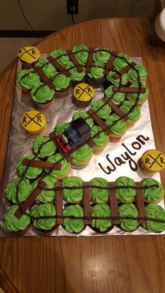 a train themed birthday cake with cupcakes on the top and numbers in the middle