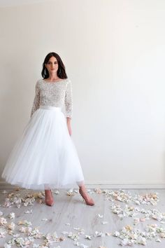 a woman in a white dress is standing on the floor with flowers all around her