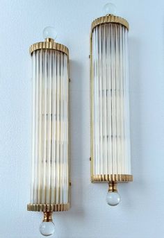 two wall sconces mounted to the side of a wall next to each other