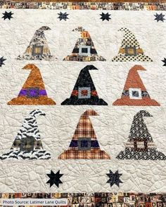 a quilted wall hanging with many hats on it