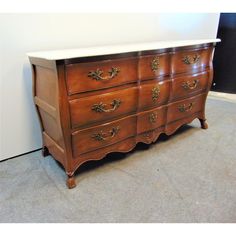 a wooden dresser with white top and drawers