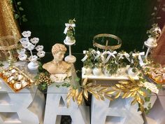 an assortment of decorative items on display in front of a green wall with gold and white decorations