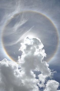 a rainbow ring in the sky with clouds