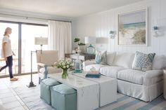 a living room filled with white furniture and lots of blue decor on top of it