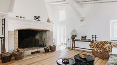 a living room filled with furniture and a fire place in the middle of an open floor plan