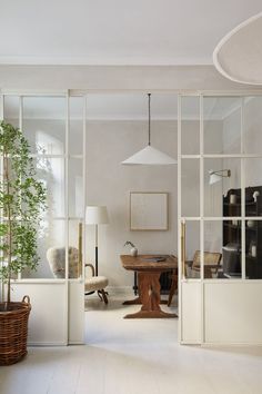 a living room filled with furniture and lots of glass doors leading to a dining area