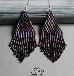 a pair of beaded earrings on top of a table