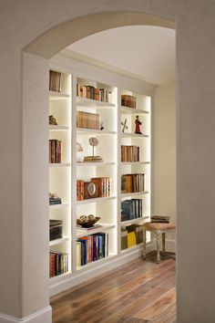 a room with several bookshelves filled with different types of books on it's shelves