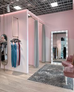 a room with pink walls and clothes on hangers