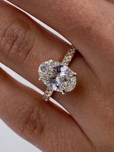 a woman's hand with a diamond ring on top of her finger and an engagement band