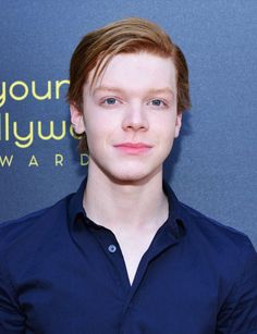 a young man with red hair wearing a blue shirt