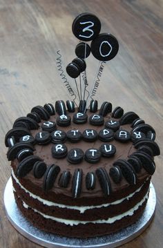 a chocolate cake with white frosting and black decorations