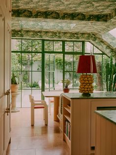 a kitchen with green walls and flooring next to a dining room table filled with food