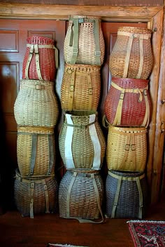 four wicker baskets stacked on top of each other in front of a wooden door