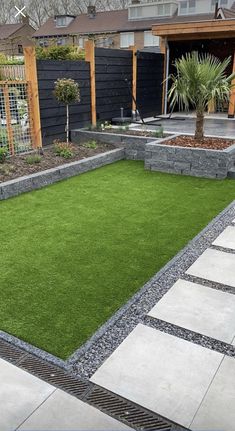 a small backyard with grass and landscaping