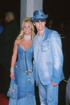 two people standing next to each other wearing blue outfits