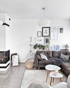 two pictures of a living room with couches, tables and pictures on the wall