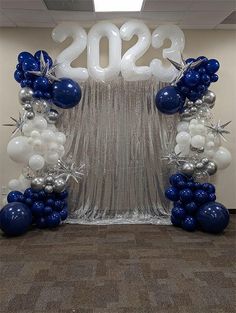 balloons and streamers in the shape of numbers are on display at an office event