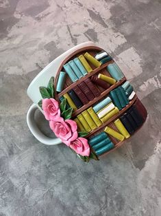 a coffee cup filled with books and flowers